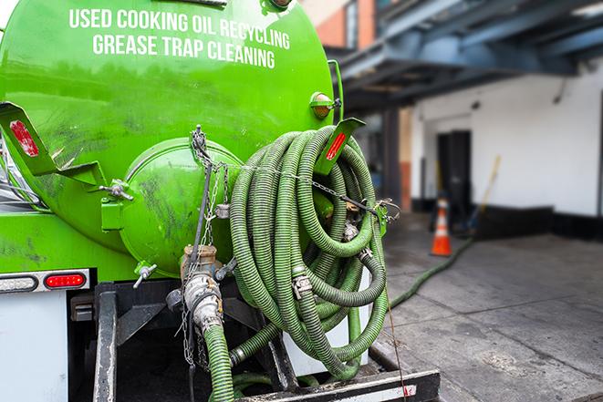 a professional technician pumping a restaurant's grease trap in Paris